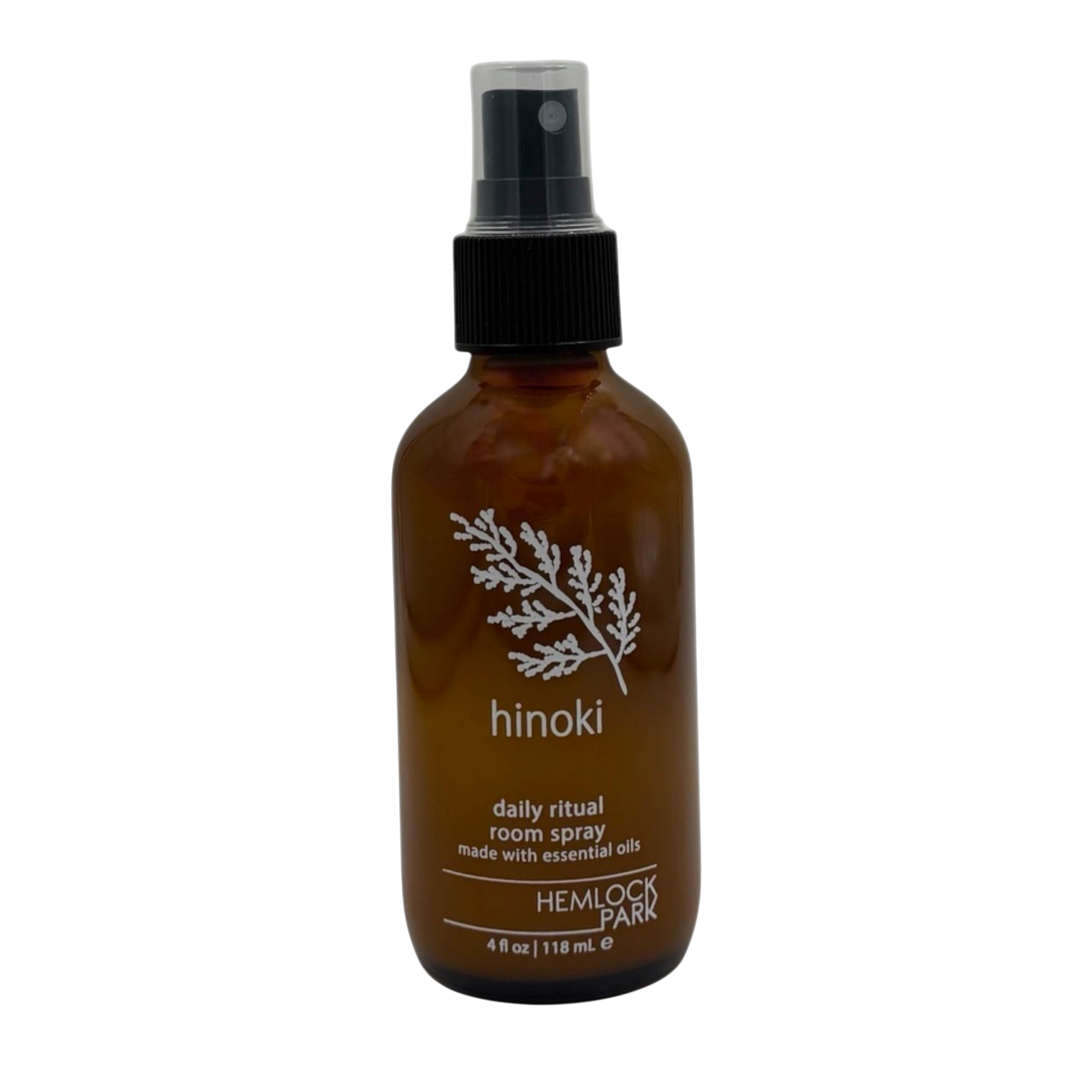 Hemlock Park Hinoki room spray in an amber glass bottle with a black spray nozzle and white botanical label design.