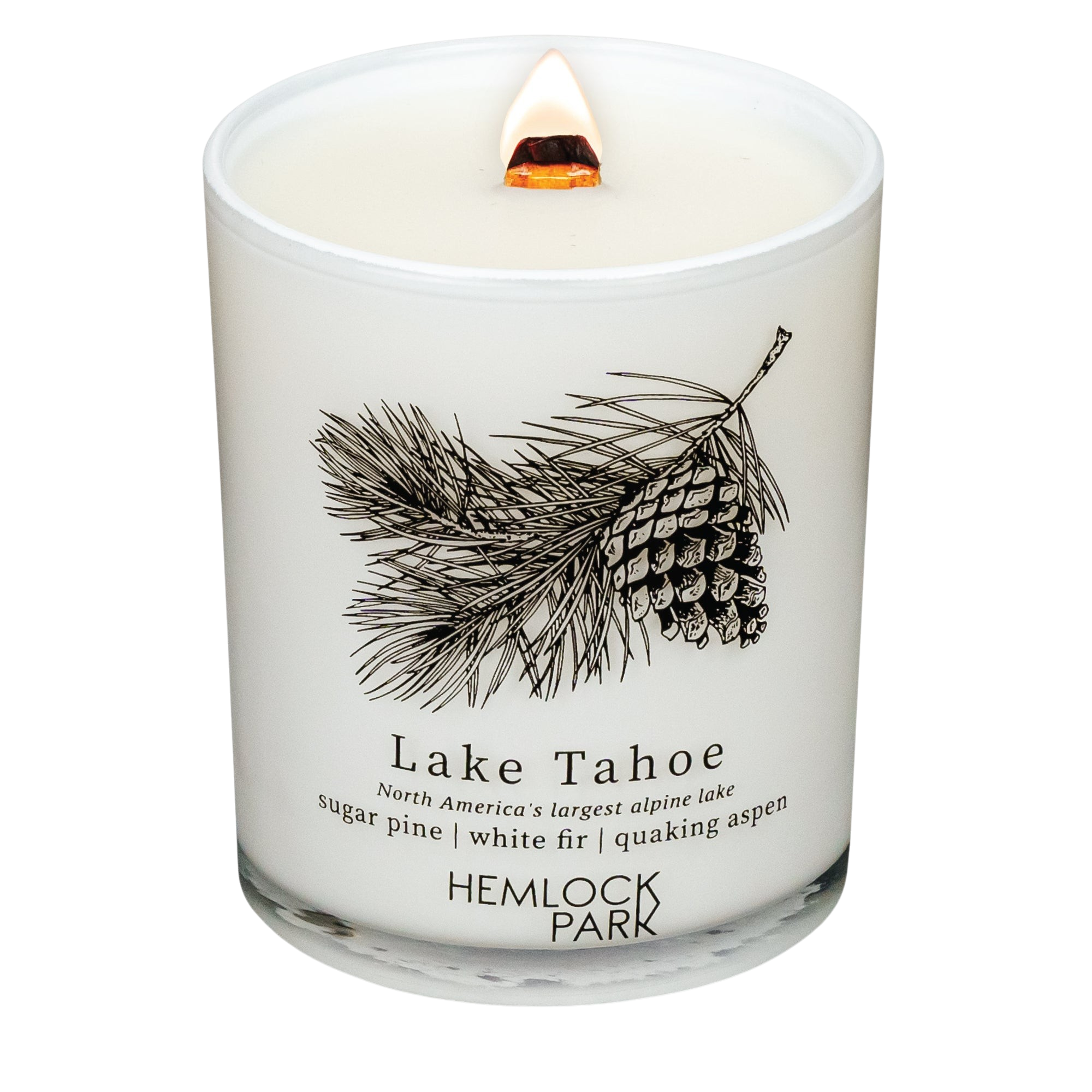 Hemlock Park Lake Tahoe candle in a white glass jar with a pinecone illustration and a lit wooden wick